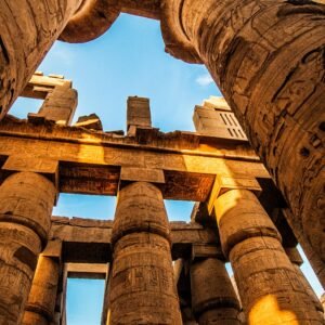 View of the majestic ancient columns in Karnak Temple, Egypt, under a clear sky.